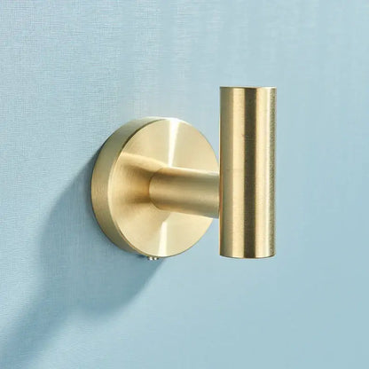 Brass-finished wall-mounted hook with circular base and cylindrical arm from brushed gold stainless steel bathroom accessories set