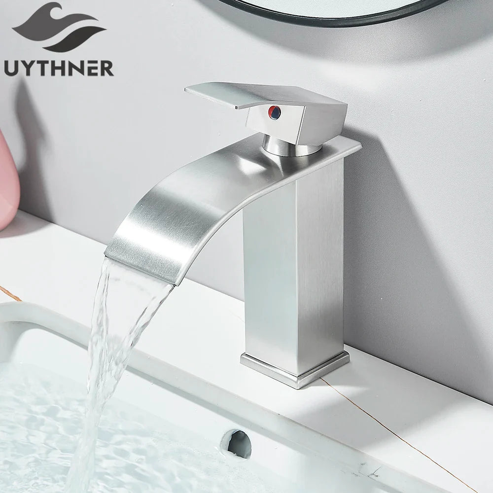 Modern brushed stainless steel single hole basin faucet with sleek angular waterfall design and red indicator dot
