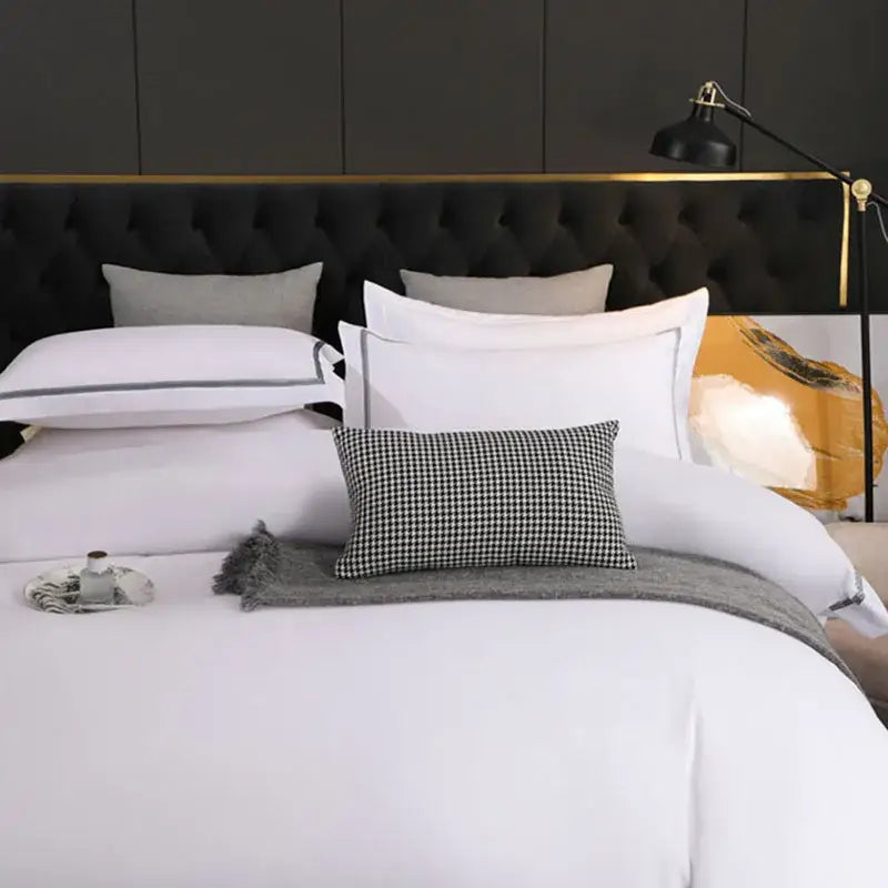 Black tufted headboard with gold trim featured in decorbites brushed hotel style white and gray bedding sets room