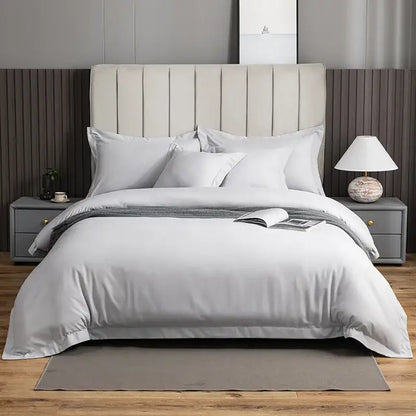 A plush light gray brushed hotel style bedding set with satin finish and subtle vertical pleats on the headboard