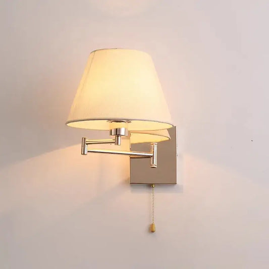 Adjustable rocker arm wall lamp with cream fabric shade and brushed nickel metal arms for living room lighting