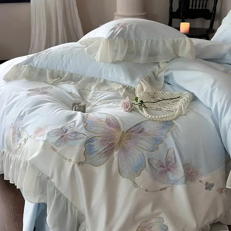Light blue cotton bedding set with decorbites butterfly embroidery and lace ruffles featuring satin duvet cover