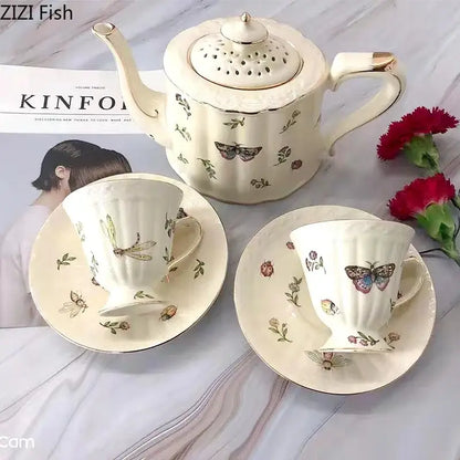 Cream-colored porcelain teapot with gold-trimmed lid and handle featuring butterfly gold ceramic motifs