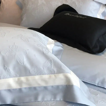 Light blue satin pillowcase with subtle butterfly jacquard embroidery and wide cream border in decorbites bedding set