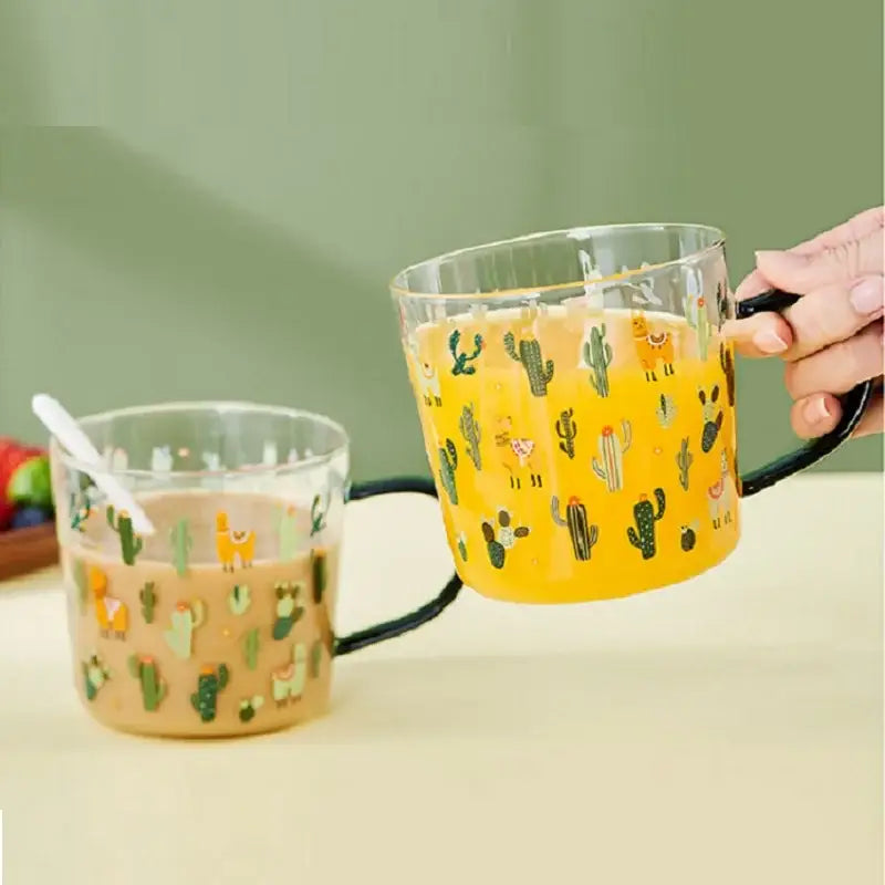 Clear glass tea milk cups with black handles featuring a playful cactus glass tea design and colorful beverages