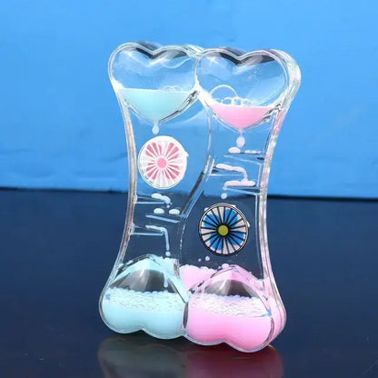 Clear heart-shaped liquid motion sand timer with blue and pink sand compartments for living room decor