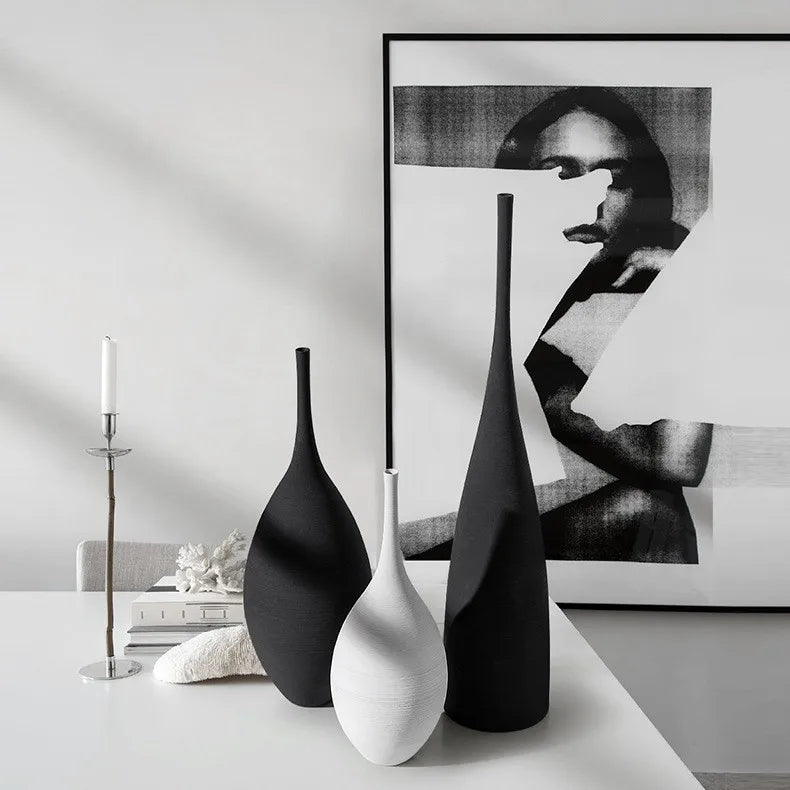 Three minimalist matte black and white ceramic vases with sleek elongated forms for nordic home decoration