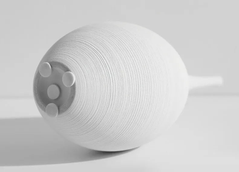 White textured ceramic capiron zen vase with narrow neck and three circular indentations for home decoration