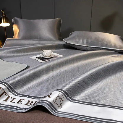 Gray satin-like carbon light cooling mat and pillowcase set with textured weave and embroidered bear decorbites carbon light