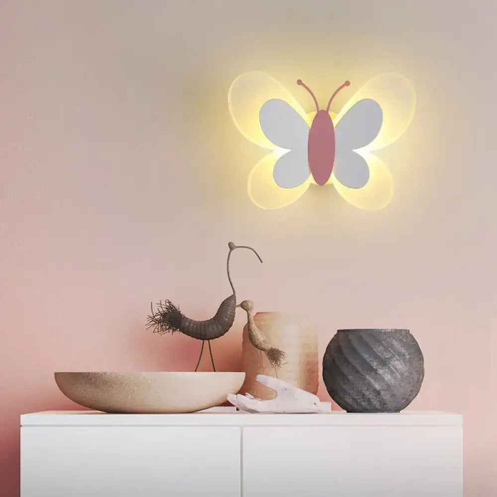 A soft glowing butterfly-shaped led wall light with white wings and pink body for kindergarten decor