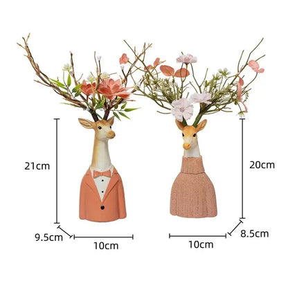 Two whimsical cartoon deer vases in beige and orange resin with floral arrangements for living room decor