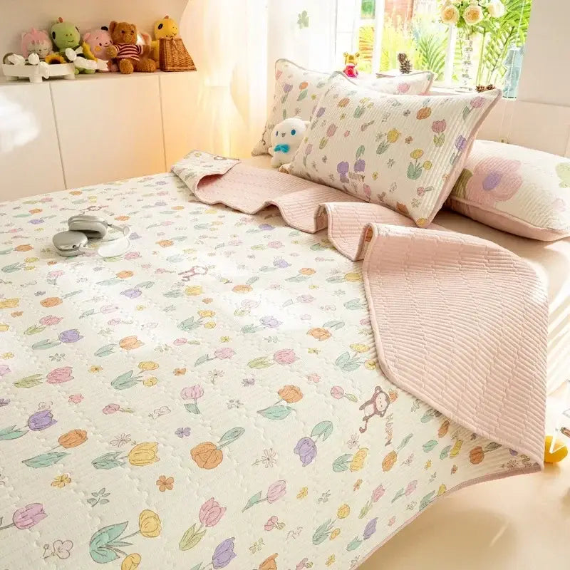 Pastel floral quilted bed cover set with soft pink ruffled edges and colorful tulip pattern on off-white cotton fabric