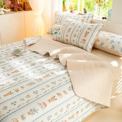 Beige quilted cotton bed cover set featuring cartoon deer and floral motifs in muted blues and browns for bedroom use