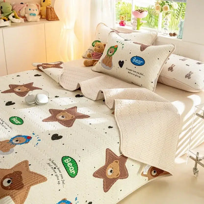 Cream-colored quilted cotton bed cover set with embroidered brown bear faces and green bear branding patches