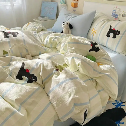 Cream-colored cotton fitted sheet set with light blue stripes and black cat appliqués holding red apples for bedroom bedding