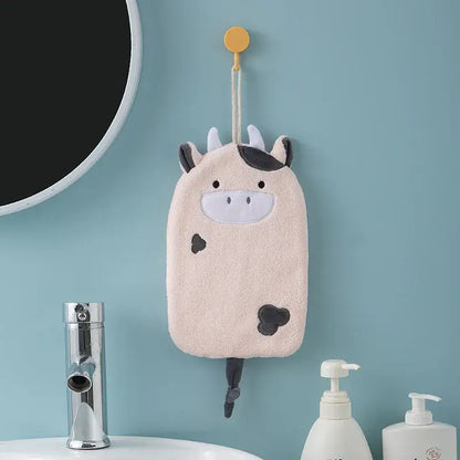 A soft plush cow-shaped bath sponge with black spots hangs from a yellow hook as decorbites cartoon embroidery hand towel