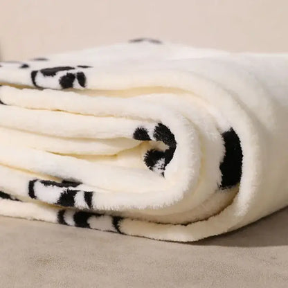 A plush white cartoon panda flannel fleece blanket with black panda faces and pom poms for bedroom decorbites decor