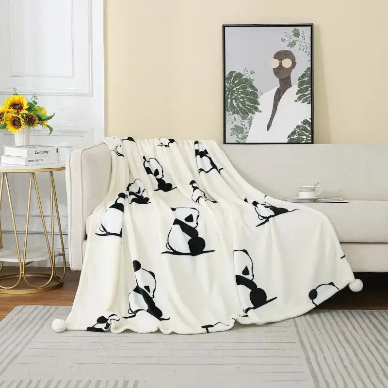 A soft white cartoon panda flannel fleece blanket with black panda silhouettes and pom poms for bedroom decorbites cartoon panda