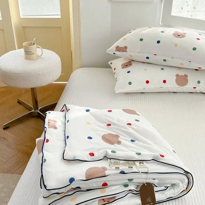 White quilt with colorful polka dots and beige bear faces neatly folded featuring decorbites cartoon patchwork summer design