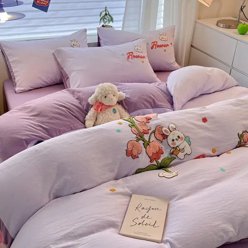 Lavender-colored bedding sets with cartoon pattern embroidered bunnies and pink flowers on soft textured fabric by decorbites