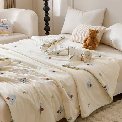 Cream-colored quilted cooling summer blanket with plush texture and embroidered cartoon mice holding strawberries pattern