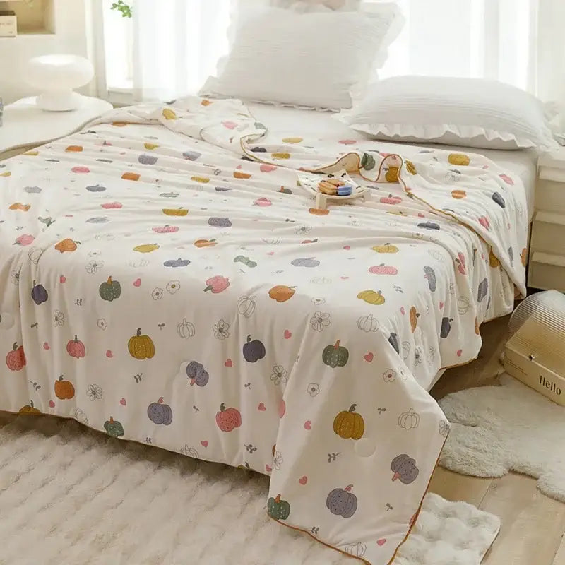 A soft off-white cotton cooling summer blanket featuring multicolored pumpkin and flower patterns for bedroom use