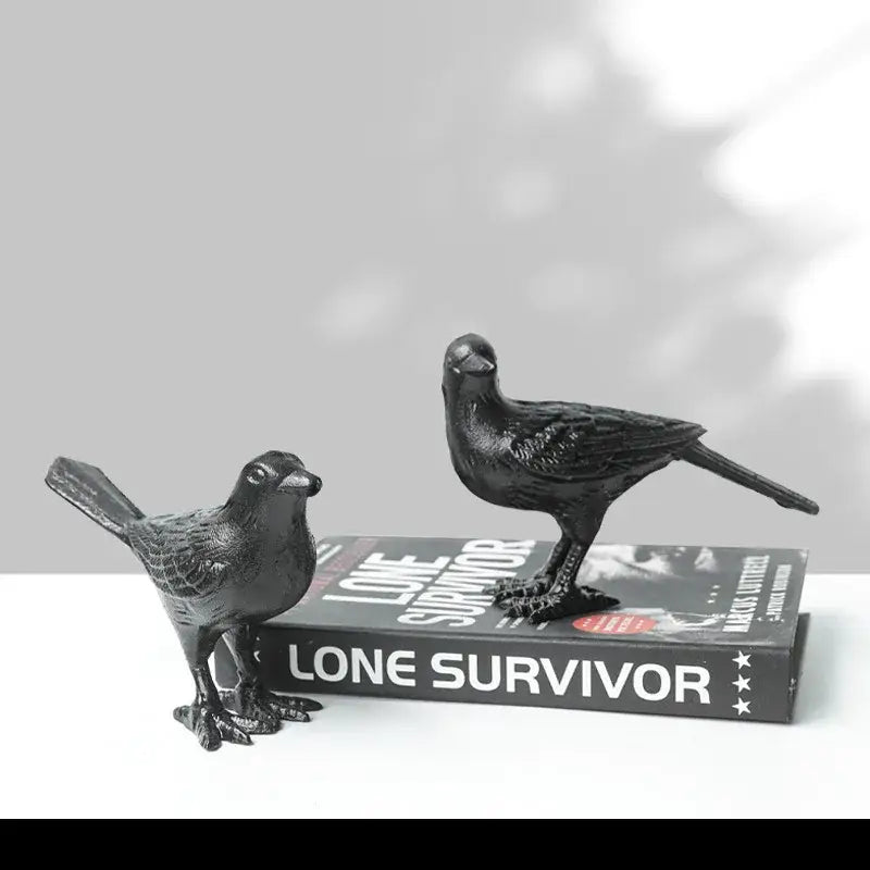 Black iron bird decoration with detailed feather texture and sturdy legs positioned on a book for living room display