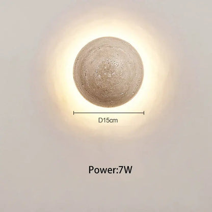 A round textured concrete wall lamp with cave stone yellow finish providing warm bedroom ambiance decorbites cave stone