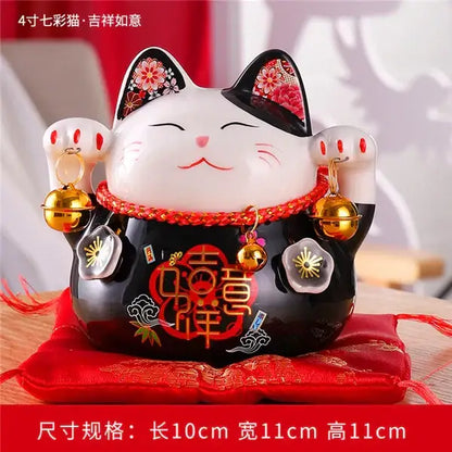 White and black ceramic maneki neko piggy bank with red floral accents and gold bells for living room decor by decorbites ceramic maneki