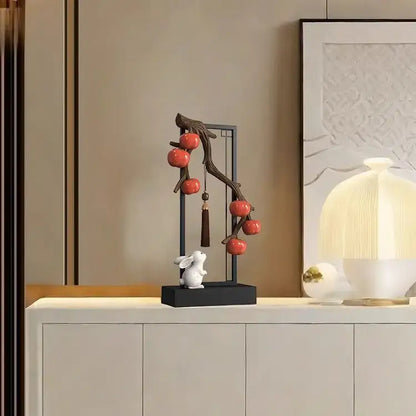 Delicate ceramic home decor set featuring a white rabbit beneath red persimmon branch for living room display