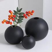 Set of three ceramic round vase black white in matte black, one holding a branch with red and orange berries