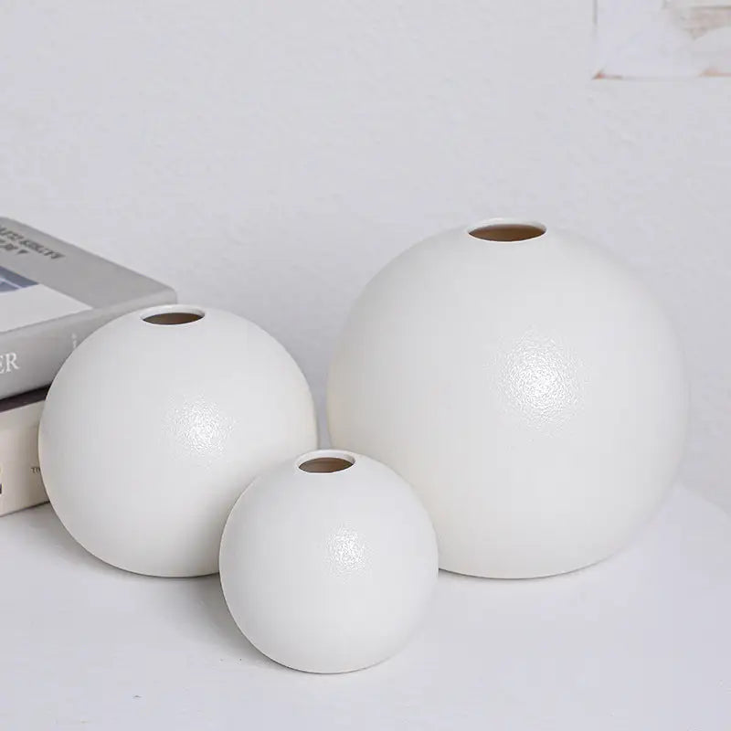 Set of three white ceramic round vases with matte finish and uniform circular openings from vase black white collection