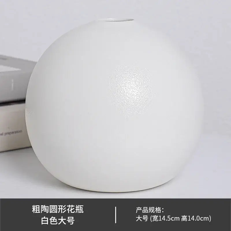 A sleek matte white ceramic round vase with a bulbous shape and subtle texture in vase black white style
