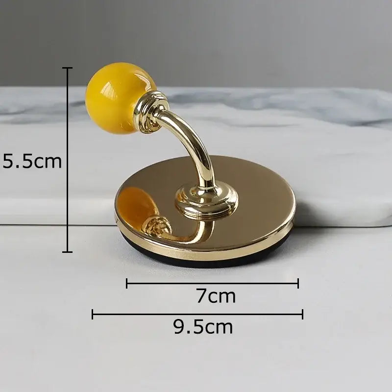 Gold-toned ceramic wall hook with glossy yellow spherical handle and circular base for decorbites colorful wall storage organizer