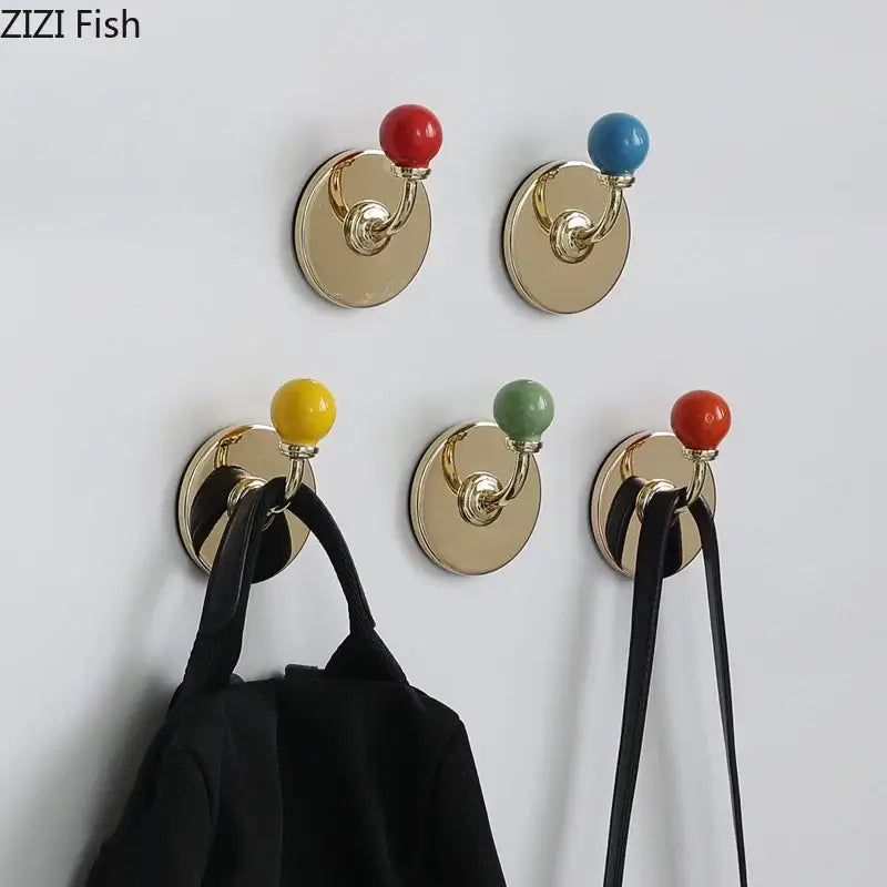 Gold-toned wall hooks with colorful ceramic ball tops in red blue yellow and green for decorbites colorful wall storage organizer