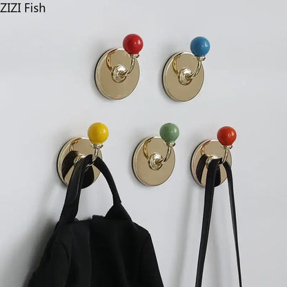 Gold-toned wall hooks with colorful ceramic ball tops in red blue yellow and green for decorbites colorful wall storage organizer