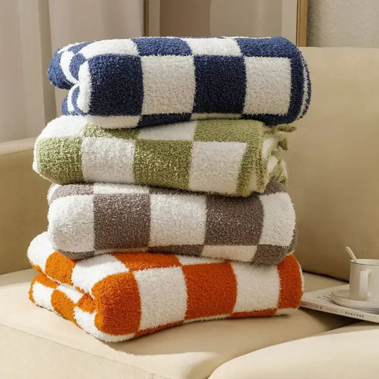 Stack of four plush decorbites knit checkerboard blankets in navy, olive, brown, and orange for bedroom and living room decor