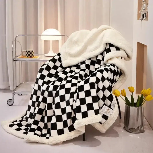 A cozy black and white checkered decorbites checkerboard lamb fleece blanket with plush cream fleece lining for bedroom throw