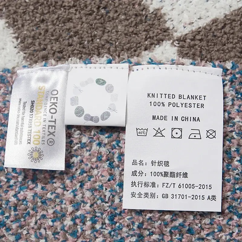 Back side of white woven care label for checkered beige and white decorbites knitted blanket throws 130x160cm 100% polyester