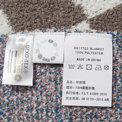 Back side of white woven care label for checkered beige and white decorbites knitted blanket throws 130x160cm 100% polyester