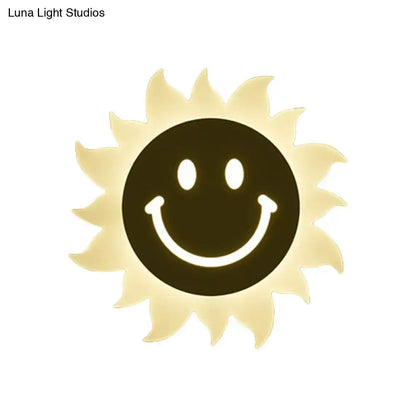 A warm yellow led wall sconce shaped like a smiling sun with radiant rays for bedroom lighting