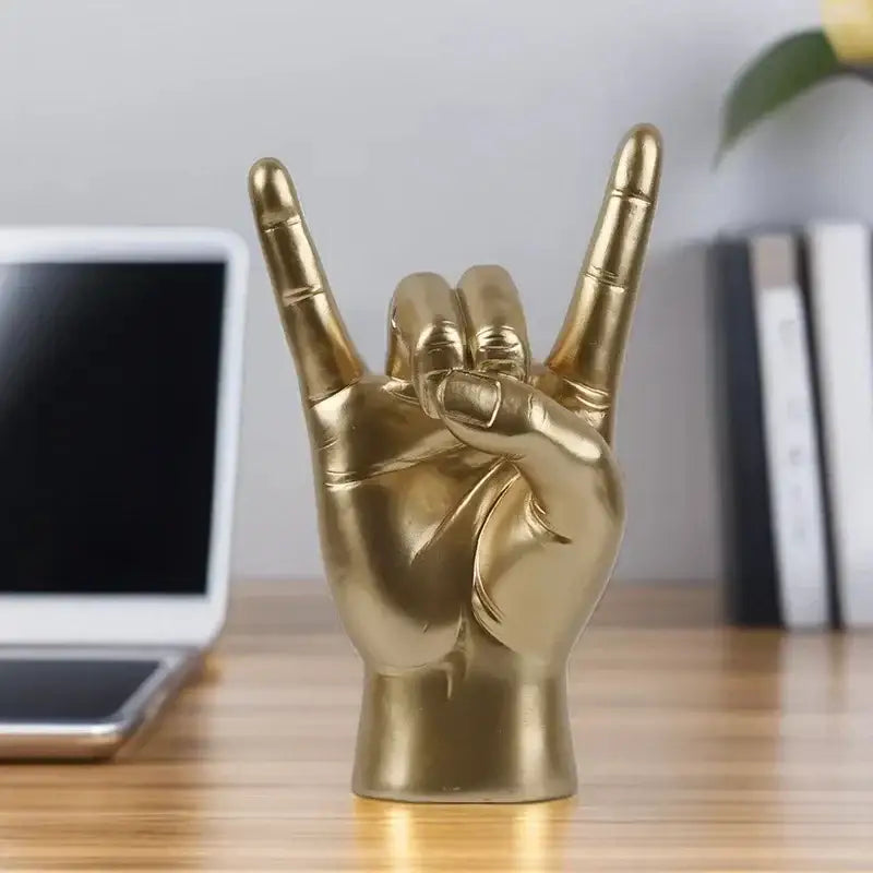 Chic black glossy hand gesture sculpture featuring a golden metallic rock hand gesture for living room decor