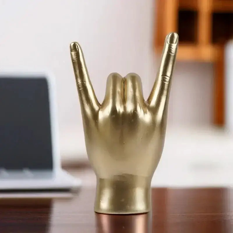 Chic black glossy hand gesture sculpture featuring a golden metallic rock gesture for living room decor