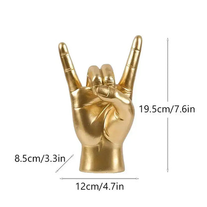 Golden metallic hand gesture sculpture of a rock on sign for chic black glossy living room decor