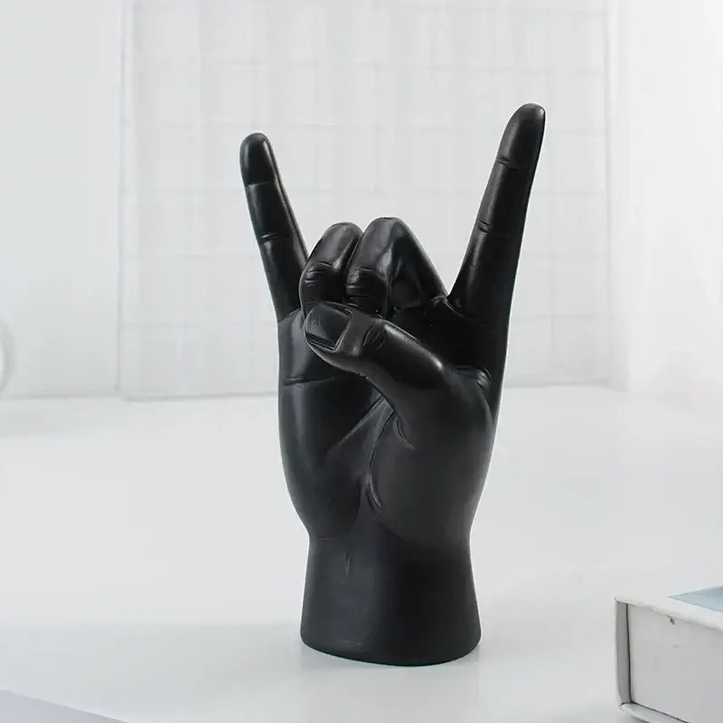 Chic black glossy resin hand gesture sculpture making a rock gesture for living room decor