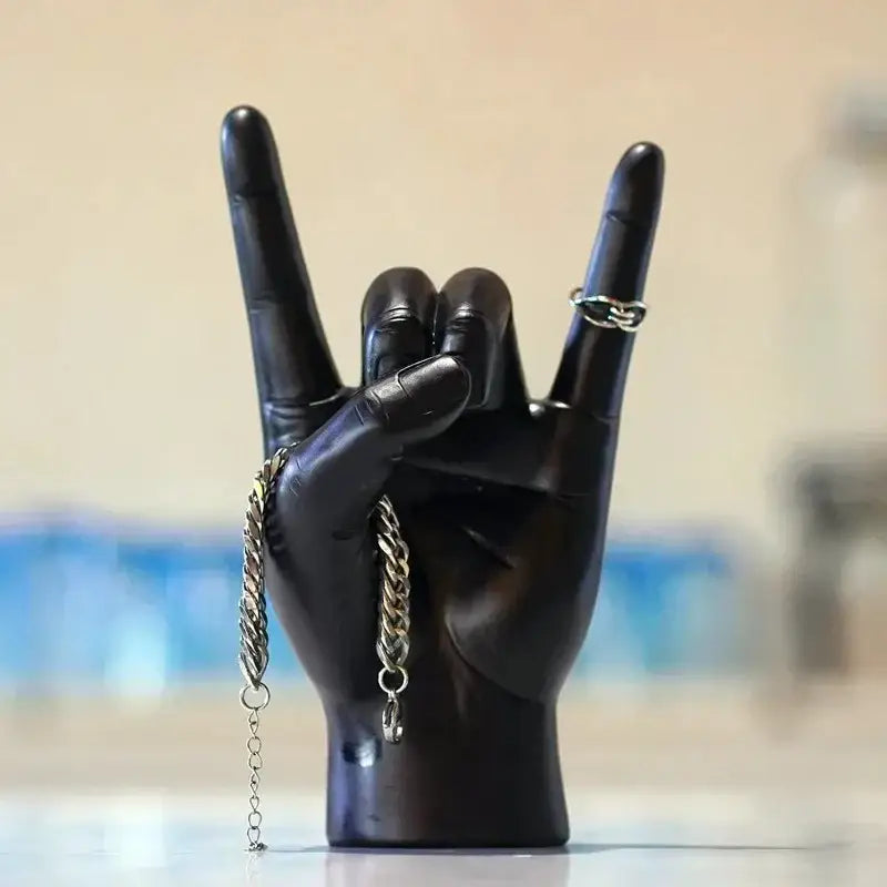 Chic black glossy resin hand gesture sculpture making a rock gesture with silver chain bracelet for living room decor