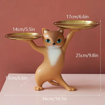 A chic cream and gold decorbites cat resin tray featuring a tan cat figurine with blue eyes balancing golden plates
