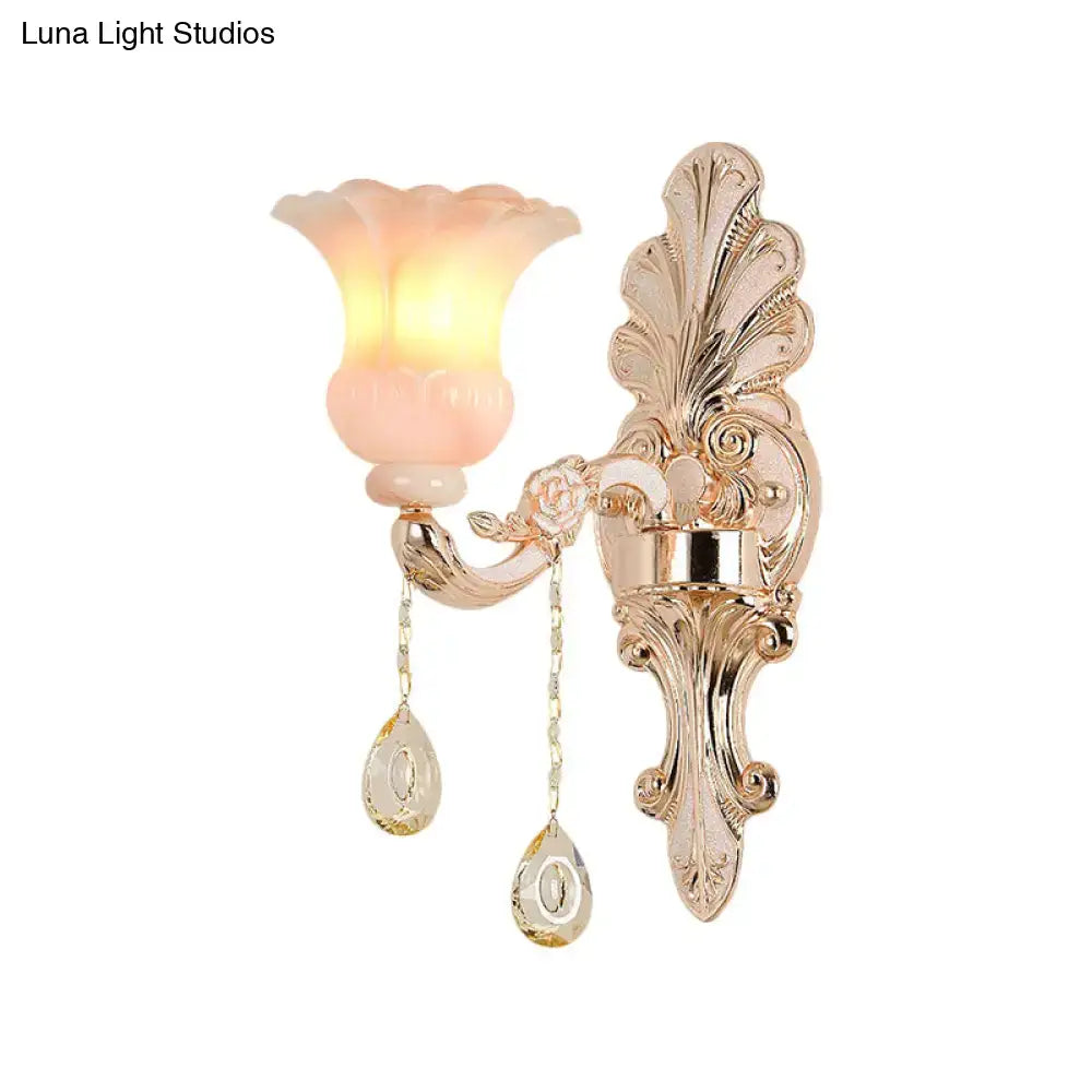 Chic gold wall lamp with pink translucent flower shade and crystal teardrop pendants for elegant bedroom decor