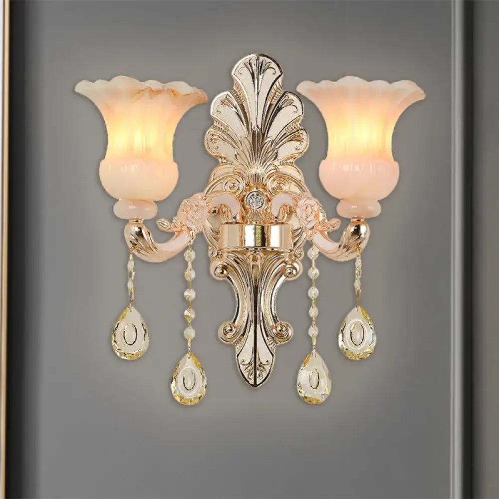 Chic gold and pink crystal wall lamp with two frosted peach glass shades and crystal teardrop pendants for bedroom