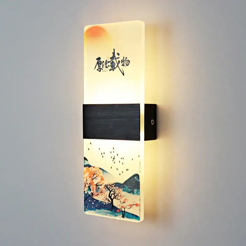 A rectangular wall lamp with glowing acrylic shade featuring a traditional Chinese landscape and black wood-textured accents